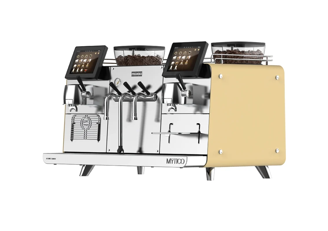 En Mytico kommersiell espressomaskin med doble kverner, flere tuter og digitale grensesnitt, med et gult sidepanel.