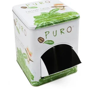 En metallboks med puro-kaffe med grønt bladdesign, som viser en fugl og kaffebønner, og har en dispenseringsåpning nederst.