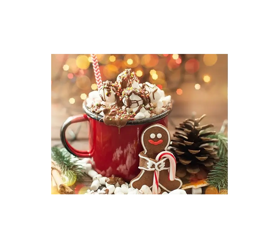 Et festlig rødt krus fylt med varm julekaffe toppet med pisket krem, en pepperkake og en sukkerstang, omgitt av feriedekorasjoner.