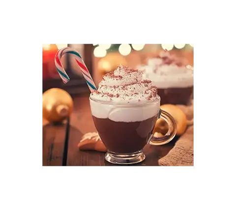 En festlig varm sjokolade toppet med pisket krem og kakao, pyntet med en sukkerstang, satt på et trebord med julepynt i bakgrunnen, inspirert av julekaffe oppskrifter